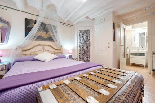 - une chambre avec un lit king-size et des draps violets dans l'établissement El Capricho de Alcorisa, à Alcorisa