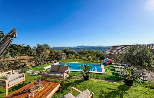 a backyard with a pool and a table and chairs at Awesome Home In Fayence in Fayence