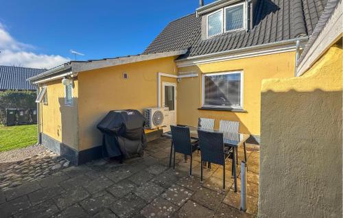 a house with a table and chairs and an umbrella at 2 Bedroom Gorgeous Home In Østermarie in Østermarie