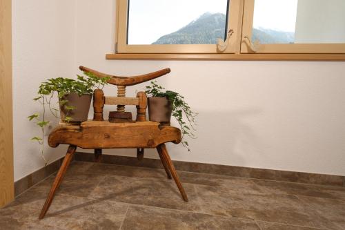 a wooden chair with potted plants sitting in a room at Landhaus Zell in Längenfeld