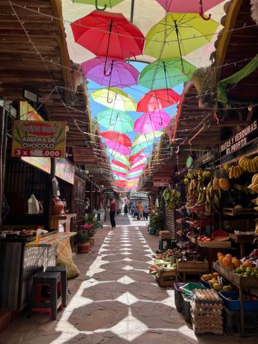 a market with colorful umbrellas hanging over a street at Hotel Boutique el Fique in Los Santos