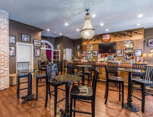 a bar with tables and chairs in a restaurant at Hotel Mazarin in New Orleans