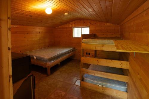 a cabin with two bunk beds in it at Plymouth Rock Camping Resort Studio Cabin 2 in Elkhart Lake