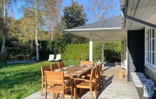 ホーンバックにあるGorgeous Home In Hornbæk With Wifiのパティオにある木製のテーブルと椅子