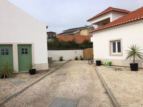 a driveway of a house with a green door at Consciência Viva in Encarnação