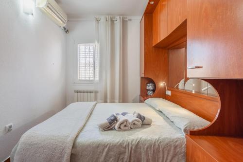 Un dormitorio con una cama con cabecero de madera. en Maison La Coquette L' Escala, en L'Escala