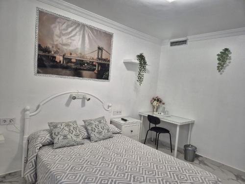 トレモリノスにあるHabitaciones Torremolinosのベッドと机のある白い寝室