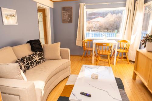 a living room with a couch and a table at 3 Bedroom Gardenside Downtown Home in Whitehorse