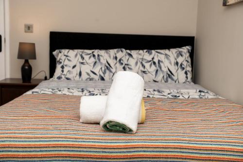 a bed with two rolled towels on top of it at RB home Stockport in Stockport