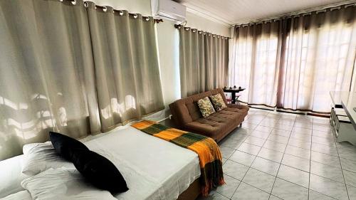 ein Schlafzimmer mit einem Bett und einer Couch in einem Zimmer in der Unterkunft Apartamento no Centro de Gramado, 700 m da Rua Coberta in Gramado