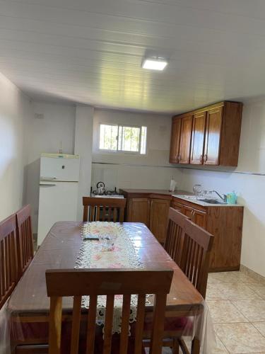 a kitchen with a wooden table and a refrigerator at Departamentos Don Julio in Guaraní