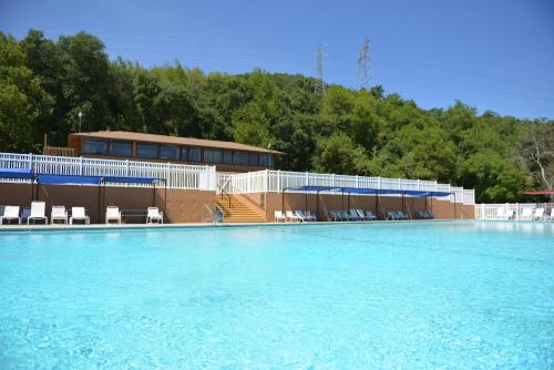 een groot zwembad met stoelen en een gebouw bij Morgan Hill Camping Resort Cottage 3 in San Martin