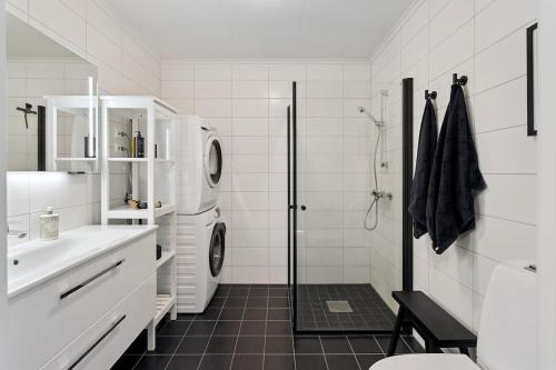 a white bathroom with a washer and dryer at Modern apartment in Elverum in Elverum