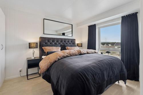 a bedroom with a large bed with a large window at Modern apartment in Elverum in Elverum