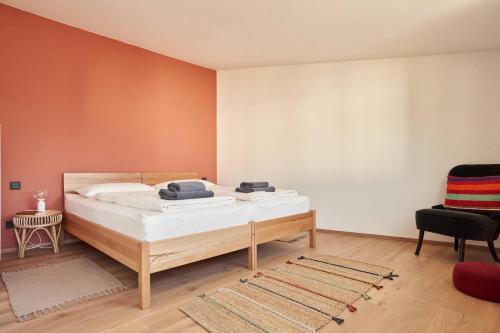 a bedroom with a bed and a chair at Alte Seifensiederei - Lallaji in Bad Tölz