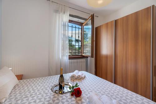 1 dormitorio con 1 cama con 1 botella de champán en Residenza Jasmine Yellow Apartment, en Verbania