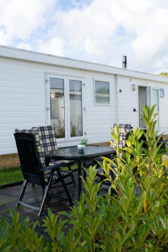 a patio with a table and chairs in front of a house at Chalet Koolmees in Anloo