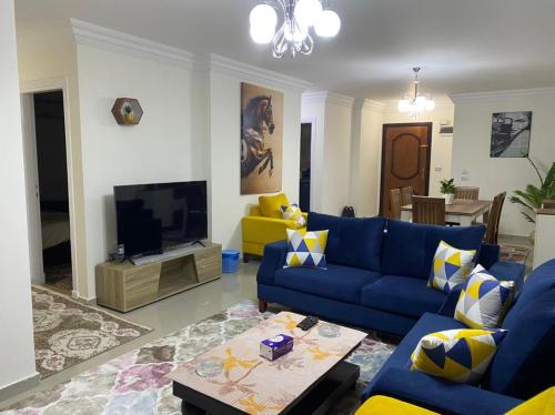 a living room with a blue couch and a tv at Wide Seaview 3-Bedroom Apartment in Alexandria