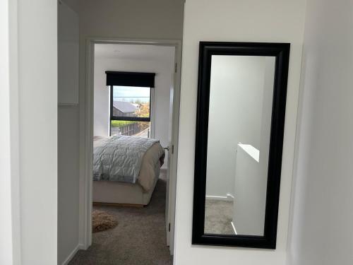 a mirror next to a bedroom with a bed at The Park Premium 2 Bedroom Apartment in Christchurch