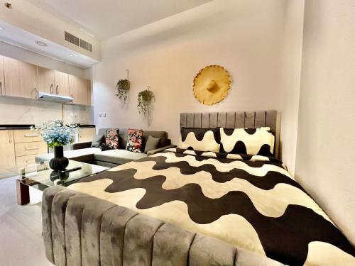 Karama pretty unit near metro في دبي: غرفة نوم مع سرير مطبوع حمار وحشي وأريكة