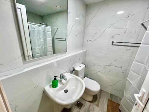 Karama pretty unit near metro في دبي: حمام أبيض مع حوض ومرحاض