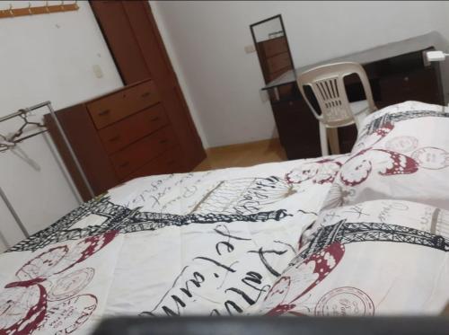 ein Bett mit einer Bettdecke, auf der „Frohes neues Jahr“ steht in der Unterkunft Pernoctancia in La Pampilla