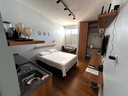 a small room with a bed and a sink at Flats Sol e Brisa in Marechal Deodoro