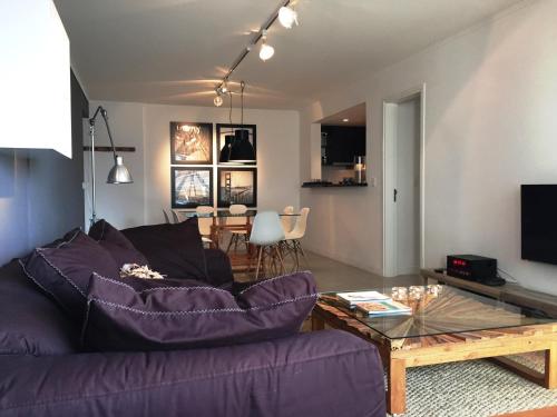 プンタ・デル・エステにあるForest Tower 2 - Apartamento 305の紫色のソファとテーブル付きのリビングルーム