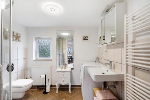 a white bathroom with a sink and a toilet at Wünsch Dir was in Großweitzschen