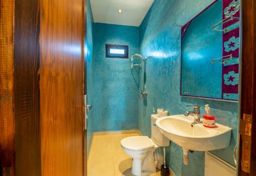 a bathroom with a white toilet and a sink at Villa Mazigh & piscine in Marrakech