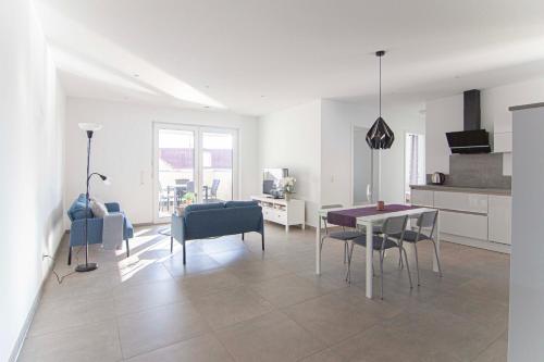 un soggiorno bianco con tavolo e sedie di Orscholz a Orscholz