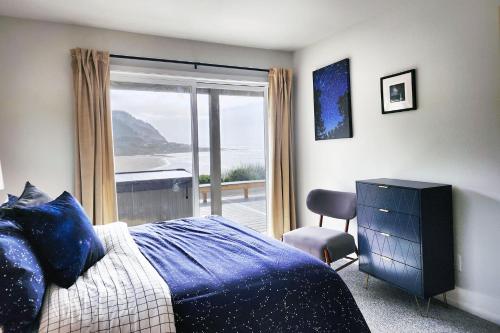 a bedroom with a bed and a view of the ocean at Oceanfront Views! Hot Tub! Starlit Shores in Yachats