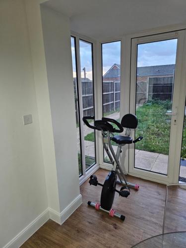 a room with a exercise bike in front of windows at Luxury Kingsize Bedroom with Dedicated Toilet- Central Dartford in Dartford