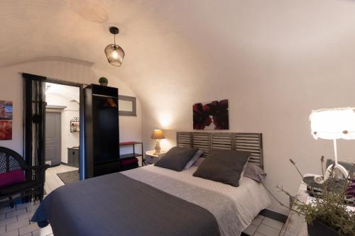 une chambre avec un lit et un miroir dans l'établissement Maisonnette de charme Bord Ardèche, à Lanas