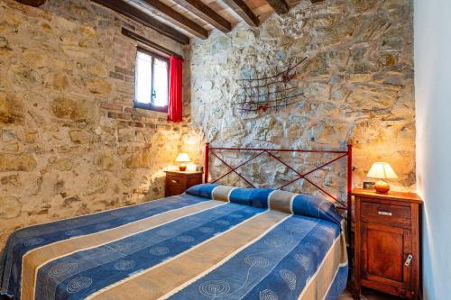 Giano dellʼUmbriaにあるRosa - Agriturismo Foglianiのベッドと石の壁のある寝室