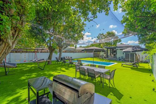 a yard with tables and chairs and a pool at CasaMia Only 10 min to Wynwood with New Pool, Bikes, Parking and Privacy in Miami