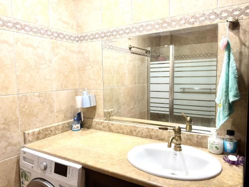 a bathroom with a sink and a washing machine at Villa Lynn in Athens