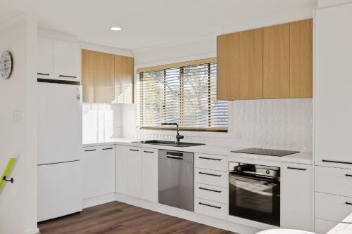 una cucina bianca con mobili bianchi e un lavandino di Seahaven Views a Ventnor