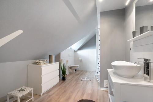 a white bathroom with a sink and a toilet at Ferienwohnung Huus 39 in Ostenfeld