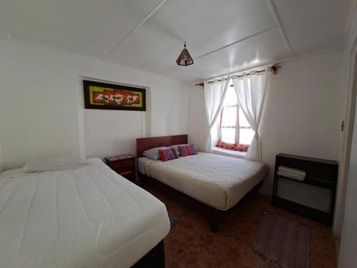 a bedroom with two beds and a window at Nativo Atacama in San Pedro de Atacama