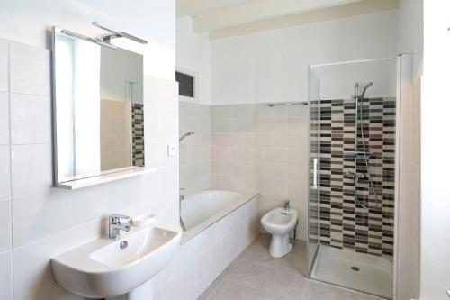 a white bathroom with a sink and a toilet at Gite de charme aux portes du Gers in Lagrange