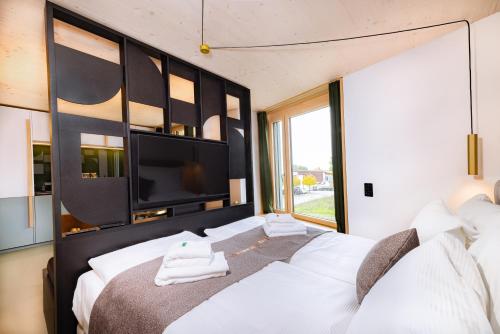 um quarto com uma grande cama branca com toalhas em VISIMO Apartments Zurich Airport em Kloten