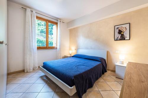 a bedroom with a blue bed and a window at Kastel's house in Roe