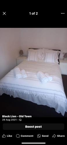 a bedroom with a bed with white sheets and pillows at The Black Lion in Bridlington