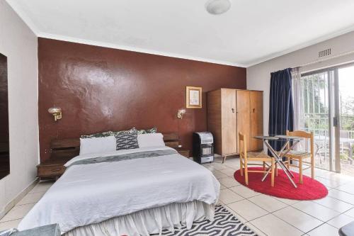 ein Schlafzimmer mit einem großen Bett und einem Tisch in der Unterkunft The Cozy 1 bedroom apartment in Roodepoort