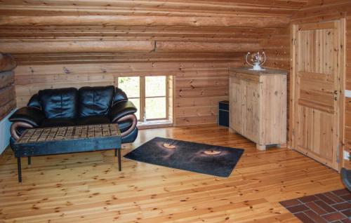 a living room with a leather couch in a log cabin at Lovely Home In Kopparberg With Sauna in Kopparberg