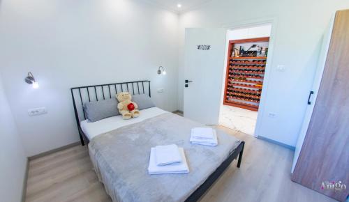 un orsacchiotto seduto su un letto in una camera da letto di Villa RM a Ivišovo Greblje