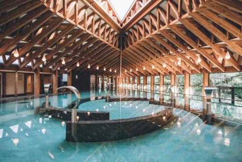 a large swimming pool in a wooden building at Chez Maïté in Vals-les-Bains