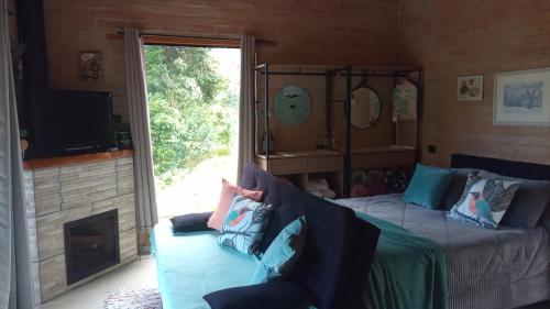 a bedroom with a bed and a fireplace and a tv at Sonho na Serra Chalé 2 in Gonçalves