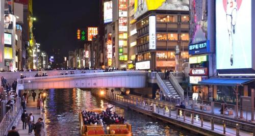 a bridge over a river in a city at night at 通天閣徒歩1分3ベッド in Osaka